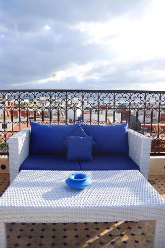a blue couch sitting on a table on a balcony at Riad Zhor Tanger - Médina in Tangier