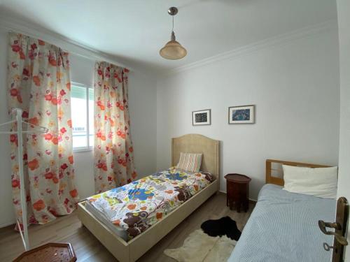 1 dormitorio con 2 camas individuales y ventana en Appartement 2 chambres salon en Casablanca
