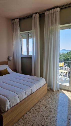 a bedroom with a bed and a large window at Residence Sabrina in Ceriale