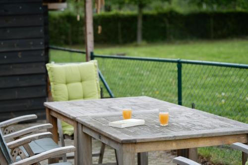 a wooden table with two glasses of orange juice on it at Op d'n Stolberg in Weert