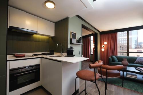 cocina con encimera, mesa y sillas en APT Serviced Apartments Santiago en Santiago