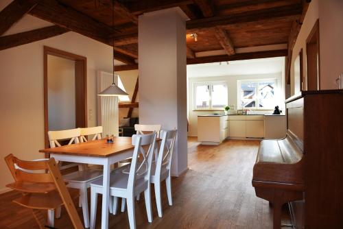 cocina y comedor con mesa de madera y sillas en Ferienwohnung "Zur Krone" - zentrale Lage - NEU - en Zell im Wiesental
