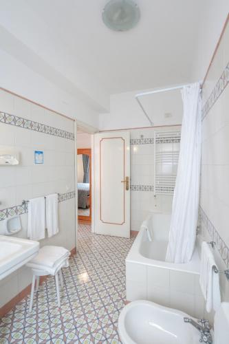 a bathroom with a tub and a toilet and a sink at Hotel Eliseo Park's in Sant'Agnello