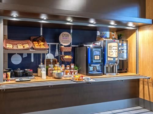 a kitchen with a counter with food and a coffee machine at B&B HOTEL Brest Port du Moulin Blanc in Brest