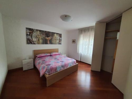 a bedroom with a bed and a wooden floor at Rendena Dolomiti House CIPAT 022244-AT-012660 in Porte di Rendena