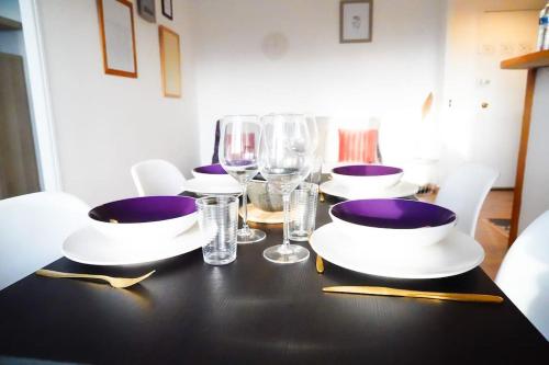 - une table noire avec des assiettes et des verres à vin dans l'établissement Le Happy • Parking • Terrasse • Calme • Fibre, à Châteauroux