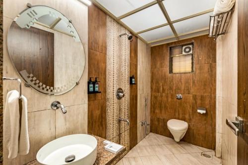 a bathroom with a sink and a mirror and a toilet at Retreat Heritage in Lonavala