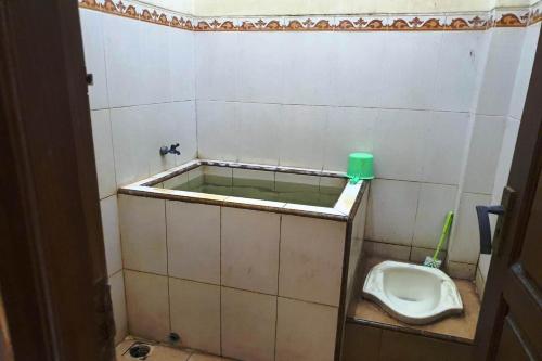 SPOT ON 93531 Homestay Puri Indah Syariah في Betro: حمام مع مبولة ومرحاض