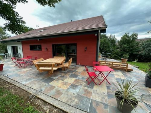 a patio with tables and chairs and a building at LES ANTHOCYANES CHAMBRE MONTAGNE in Champagny