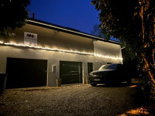 a car parked in front of a garage at night at LES ANTHOCYANES CHAMBRE MONTAGNE in Champagny
