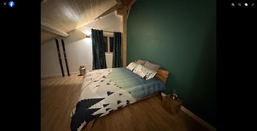 a bedroom with a bed and a green wall at LES ANTHOCYANES CHAMBRE MONTAGNE in Champagny