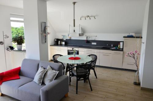 a living room with a couch and a table in a kitchen at Ferienwohnung Auszeit in Ueckeritz
