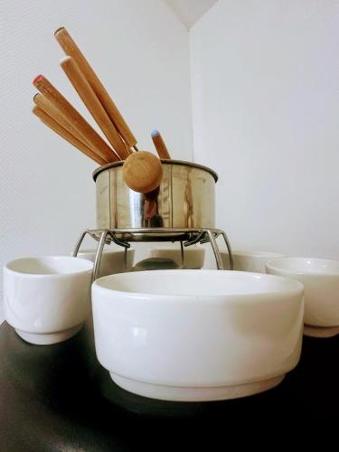 un groupe de bols et un pot sur une table dans l'établissement Gîte du gué, à Les Hautes-Rivières