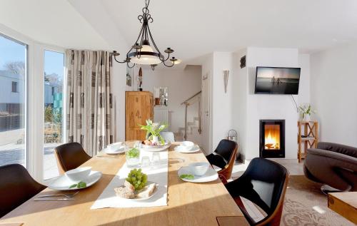 comedor con mesa, sillas y chimenea en Ferienhaus Fietje, en Zinnowitz