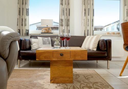 sala de estar con sofá y mesa con copas de vino en Ferienhaus Fietje, en Zinnowitz