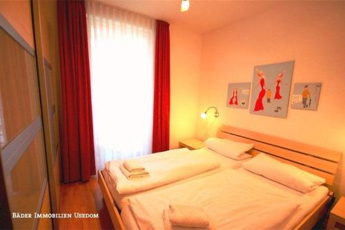 1 dormitorio con 1 cama blanca grande y ventana en Ostseeresidenz Gorki Park Nr 01, en Heringsdorf
