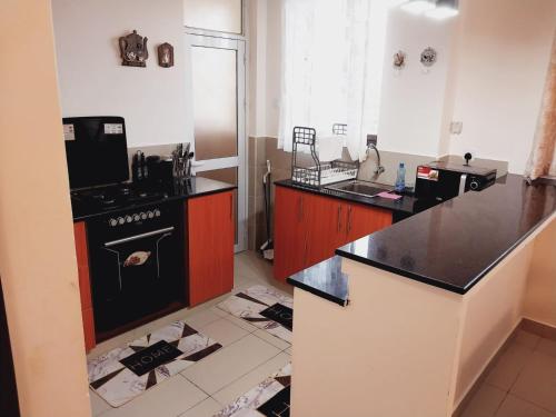 a kitchen with a stove and a counter top at Izmira Serviced Apartment Studio in Mombasa