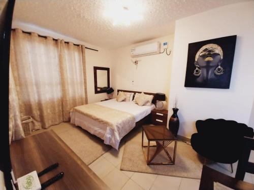 a bedroom with a bed and a table in it at Izmira Serviced Apartment Studio in Mombasa