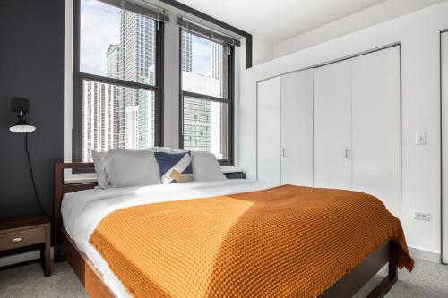 a bedroom with a bed and a large window at Ideal Loop 2BR w Gym nr Millennium Park CHI-130 in Chicago