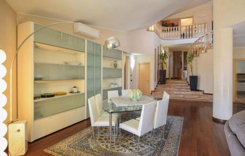 a dining room with a glass table and white chairs at Villa Paradiso by PosarelliVillas in Nestore