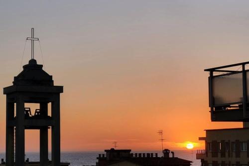 a clock tower with the sunset in the background at Happy Ladispoli - Vista Mare in Ladispoli