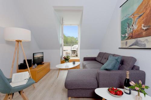 ein Wohnzimmer mit einer Couch und einem Sessel in der Unterkunft Villa Frisia Nr 29 in Bansin