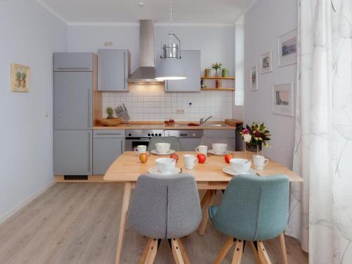 班辛海的住宿－Villa Frisia Nr 29，厨房配有木桌和两把椅子