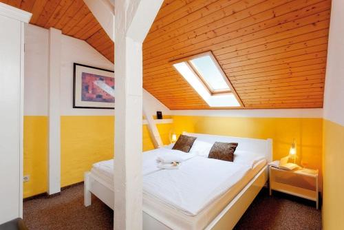 1 dormitorio con cama blanca y techo de madera en Villa Helene - Appartement 6 en Heringsdorf