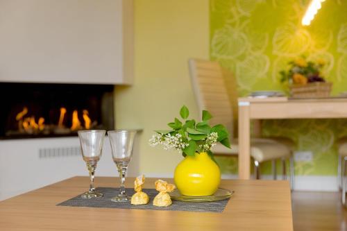 une table avec deux verres à vin et un vase jaune dans l'établissement Villa Gruner Nr 17, à Zinnowitz
