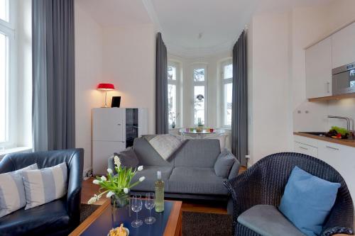 een woonkamer met 2 stoelen en een bank bij Villa Gruner Nr 8 in Zinnowitz