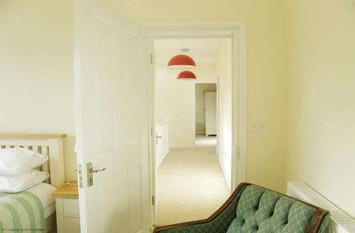 奧爾頓的住宿－Goldridge，走廊上设有床,门通往卧室