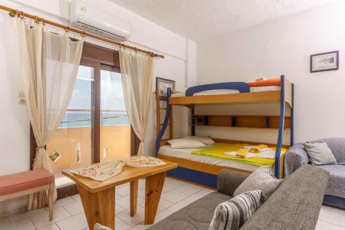 a living room with a bunk bed and a couch at Alexander Beach Hotel in Kalamaki