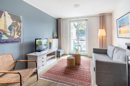 uma sala de estar com um sofá e uma televisão em Weiße Düne Nr 06 em Ahlbeck