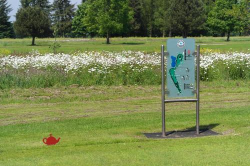 a sign in the middle of a field with flowers at Hotel Blauer Fasan in Wiesmoor