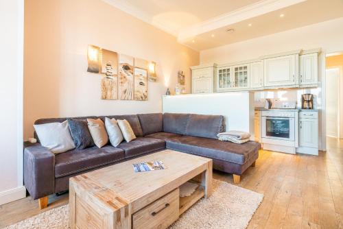 ein Wohnzimmer mit einem braunen Sofa und einem Tisch in der Unterkunft Villa Louise Nr 6 in Ahlbeck