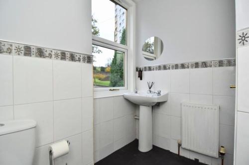 a white bathroom with a sink and a window at The Cove in Gourock
