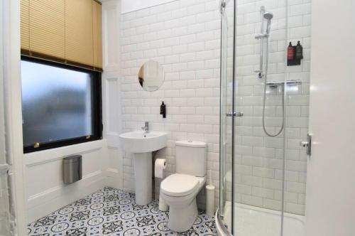 a bathroom with a toilet and a sink and a shower at The Cloch in Gourock