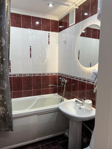 a bathroom with a bath tub and a sink at Двухкомнатная квартира в городе Экибастуз in Ekibastuz