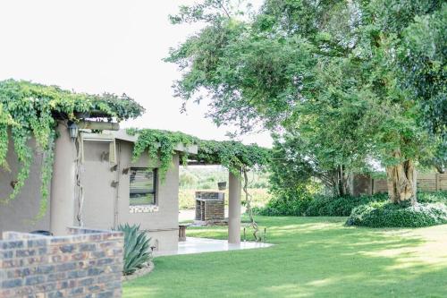 ein Haus in einem Garten mit grünem Rasen in der Unterkunft Elim Guesthouse in Keimoes