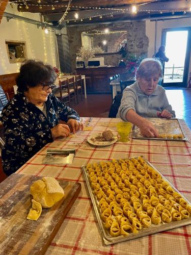 two women sitting at a table with a tray of food at B&B Podere Camaiano in Roccastrada