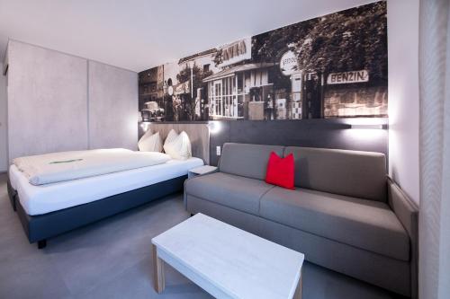 een hotelkamer met een bed en een bank bij FairSleep AVIA Motel Zwettl in Zwettl Stadt