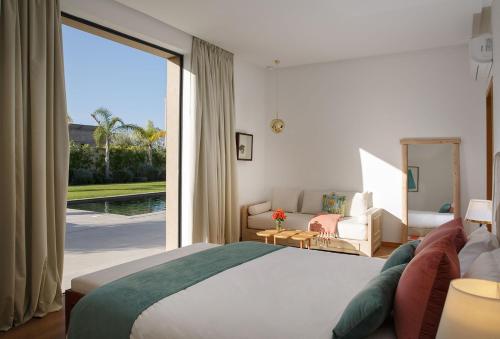 ein Schlafzimmer mit einem großen Bett und einem großen Fenster in der Unterkunft ADA ADA modern villa with heated private pool next city center in Marrakesch