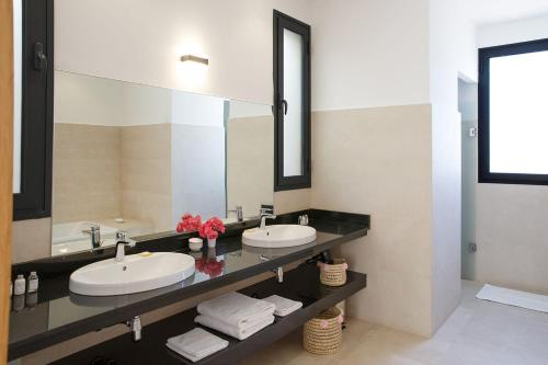 ein Badezimmer mit zwei Waschbecken und einem großen Spiegel in der Unterkunft ADA ADA modern villa with heated private pool next city center in Marrakesch