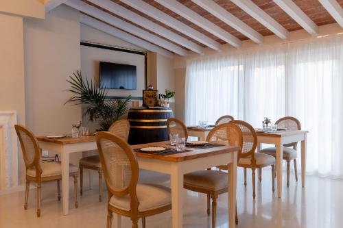 uma sala de jantar com mesas e cadeiras e uma televisão em Relais Ca' Morenica em Valeggio sul Mincio