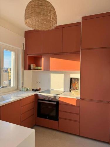 a kitchen with brown cabinets and a black oven at Porto Aldoar Boutique Flat (Inês) in Porto