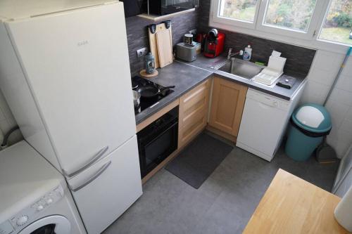 une petite cuisine avec un réfrigérateur et un évier dans l'établissement Le Paisible • Garage Privatif • Traversant • Calme, à Châteauroux