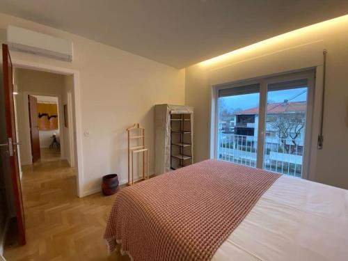 a bedroom with a bed and a large window at Porto Aldoar Boutique Flat (Inês) in Porto
