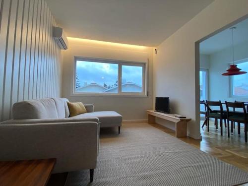 a living room with a couch and a window at Porto Aldoar Boutique Flat (Inês) in Porto