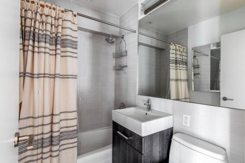 a bathroom with a sink and a toilet and a mirror at Chelsea 1br w doorman gym nr Flatiron NYC-1320 in New York