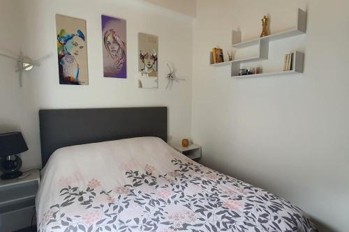 ein Schlafzimmer mit einem Bett und einige Bilder an der Wand in der Unterkunft Chai Callie, ancien Chai meublé in Cognac